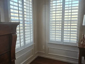 White plantation shutters installed on French doors with louvered panels and professional paint finish
