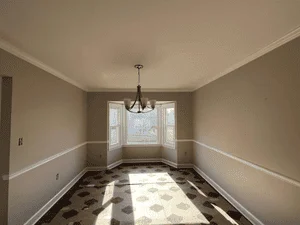 Two-tone painted dining room with beige walls, white chair rail wainscoting, and painted ceiling
