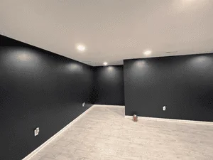 Charcoal gray painted walls with recessed lighting and white trim in finished interior room