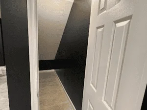 Black accent wall with white trim and doors in residential hallway
