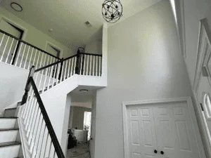White painted stairwell with railings, hallway walls, and ceiling in residential interior